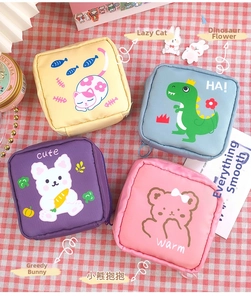 Four colorful cartoon sanitary napkin storage pouches with zippers on a plaid background