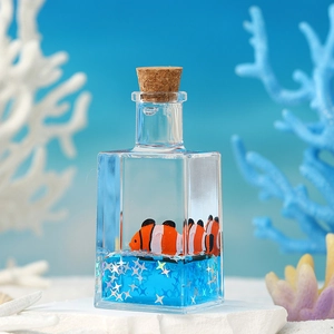 Macro detail of nautical fluid drift bottle with blue liquid and floating clownfish