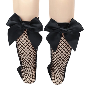 Close-up of black mesh fishnet socks with a large bow detail on a mannequin leg
