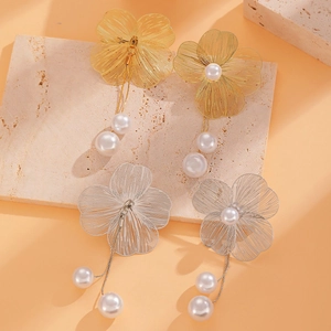 Detailed shot of gold and silver wire-woven flower earrings with elegant pearl tassels
