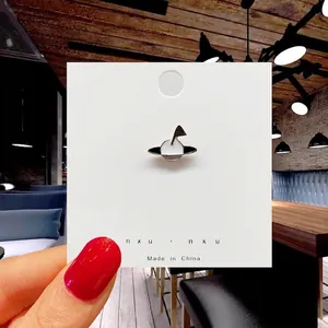 Detailed view of black and white planet enamel pin on a white retail display card