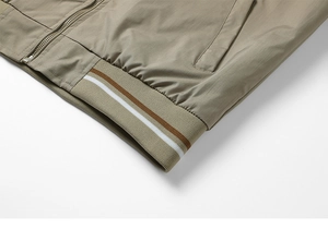 Detail of grey work jacket hem with elastic ribbed cuffs and striped patterns