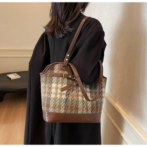 Detail of retro large capacity tote bag with brown leather and green plaid wool texture