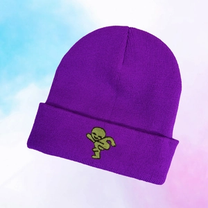 Detail der lila Strickmütze mit grüner Alien-Stickerei auf dem umgeschlagenen Rand