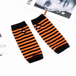 Detail of orange and black striped knit arm warmers with thumb holes on white background