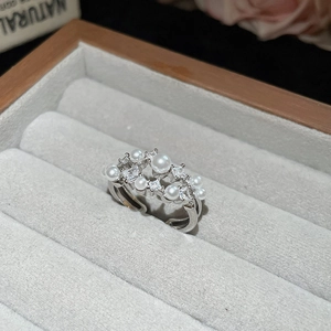 Close-up of silver zircon ring with white pearls in a grey velvet jewelry box