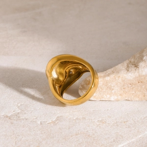 Vista macro dell'anello in acciaio inox placcato oro 18K con zircone su base di pietra