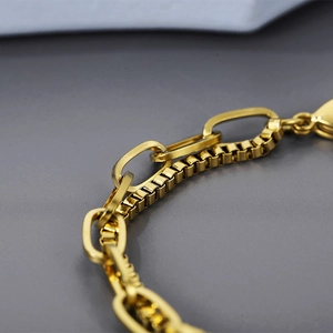 Macro shot of gold double-layer bracelet with oval links and box chain detail