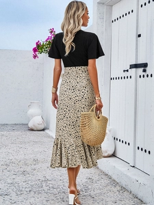 Détail d'une robe élégante à col en V avec jupe midi florale et ourlet à volants
