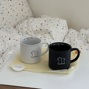 Detail of minimalist ceramic mugs featuring dog patterns and drink more water text
