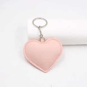 Detail of pink PU leather heart keychain with neat edge stitching and silver ring