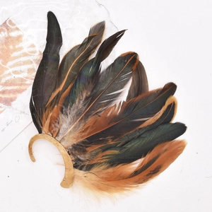 Detailed close-up of Bohemian peacock feather ear cuff with golden metallic textures