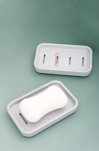 Detail of gray soap holder featuring curved drainage slots for effective water removal