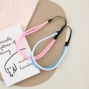 Close-up of glitter elastic headbands in pink and tricolor patterns on aesthetic background