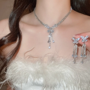 Detail showing elegant silver zircon butterfly tassel necklace and earrings on model