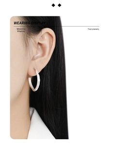 Close-up of irregular S925 sterling silver hoop earring with textured finish on model