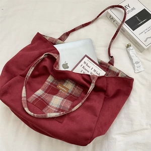 Détail d'un grand sac cabas en daim rouge avec une doublure à carreaux rouges et blancs
