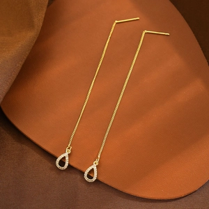 Macro detail of gold-plated tassel earrings with zircon-inlaid waterdrop pendants
