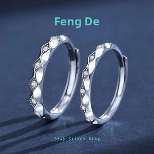 Macro shot of S925 sterling silver couple rings with wavy texture and paved white stones