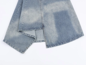 Close-up of light blue denim midi skirt hem showing fine stitching and wash texture