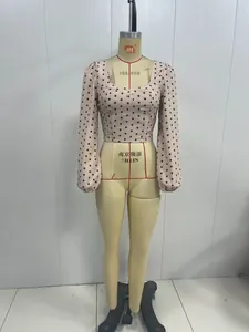 Détail du haut femme à manches bouffantes, col carré et motif à pois noirs classiques