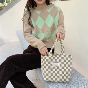 Retro corduroy handtas met schaakbordpatroon en Pleasant Time label gedragen door een model