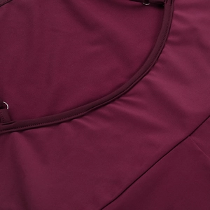 Détail du tissu élastique bordeaux avec des coutures de qualité et une texture raffinée