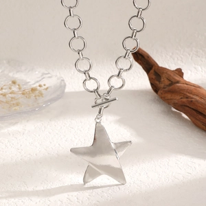 Dettaglio della collana con stella d'argento e chiusura a T su sfondo in legno rustico