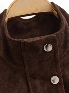 Macro detail of dark brown faux suede jacket collar with metallic silver snap buttons