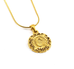 Détail d'un pendentif floral creux doré sur une chaîne de serpent élégante