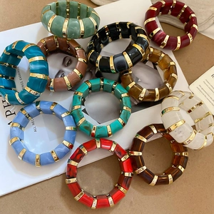 Macro shot of colorful acrylic resin blocks with marble pattern and gold metal rings