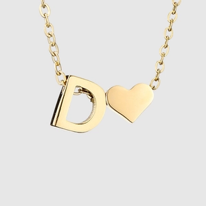 Vue macro du collier en acier doré avec pendentif lettre D et détails en forme de cœur