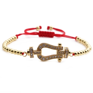 Adjustable red rope bracelet featuring a gold horseshoe buckle with white zirconia stones