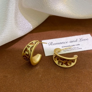 Detail of vintage matte gold C-shape earrings with leopard print cutout on velvet