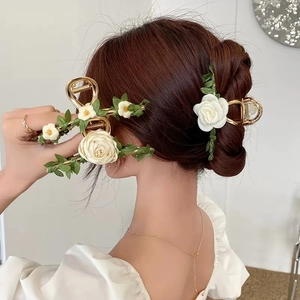 Floral hair claw clip with white roses and green leaves for elegant updo hairstyles