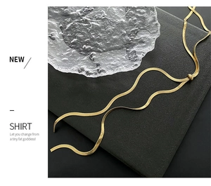 Detail of adjustable gold herringbone chain with slider bead and glossy snake texture