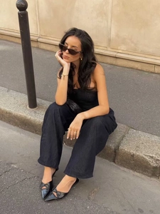 Vista dettagliata di una donna in completo bustier di jeans nero e scarpe a punta in città
