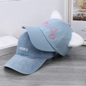 Detail of light blue baseball caps with cute plush ears and daisies embroidery