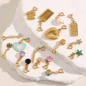 Assorted 18K gold plated heart and butterfly charms on white textured stone base
