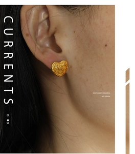 Detailed close-up of a vintage woven gold heart earring worn for a chic retro aesthetic
