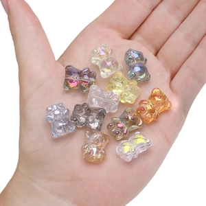 Hand holding colorful 12x14mm translucent 3D bear crystal pendants for DIY jewelry making