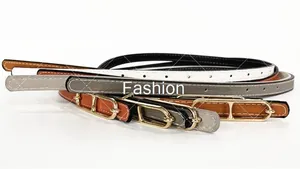 Detail of four thin Saffiano leather belts in black white grey and tan with gold buckles
