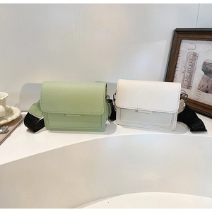 Modern light green and cream crossbody square bags displayed with wide woven straps