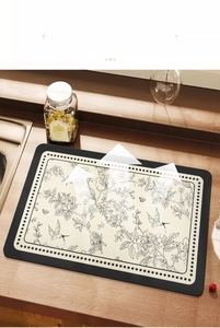 Macro shot of absorbent kitchen mat with hand-drawn floral patterns on wooden counter