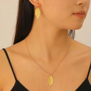 Detail of gold leaf necklace and earrings set with realistic textures on a model