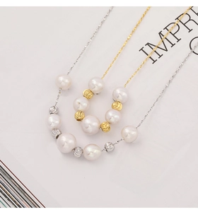 Detail of silver and gold thin necklaces with freshwater pearls and textured metal beads
