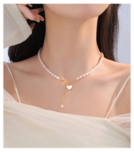Detail of freshwater pearl necklace with heart pendant on model's neck for elegant styling