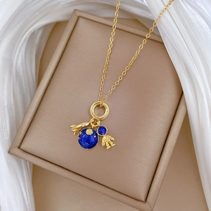 Detailed close-up of gold planet and rocket charms on a titanium steel necklace chain
