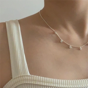 Elegant 925 sterling silver necklace with zircon pendants on model in white top
