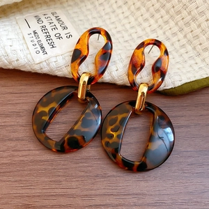 Detailed view of tortoise shell resin pendant earrings with elegant golden metal links